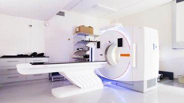 Modern CT scanner in a clean, bright medical room.