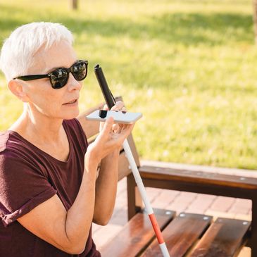 Blind woman using a braille device outdoors.