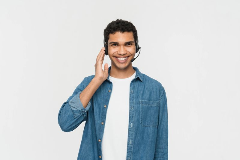 A cheerful customer service representative with a headset, expressing approachability and professionalism in a relaxed casual outfit, highlighting client-oriented communication and support in a bright and positive setting.