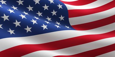 The waving flag of the United States with stars and stripes.