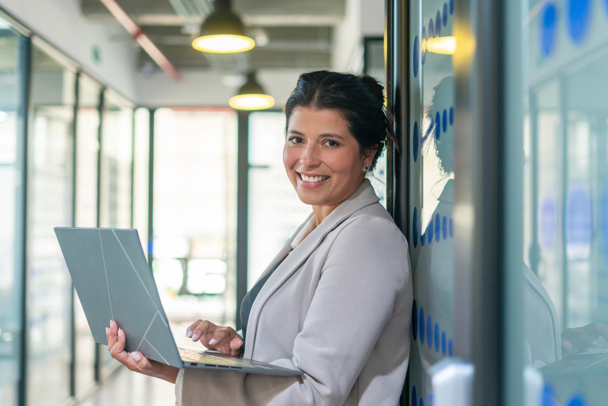 Female holding laptop smiling at the camera