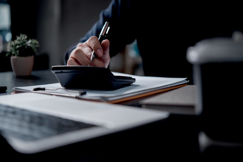 Businessman using calculator bookkeeping payroll and budget tax. Business document finance accounting investment