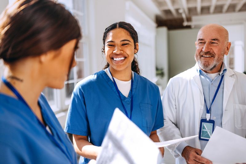 A group of medical professionals stands together in the hospital, engaged in a discussion
