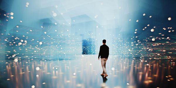 Person walking into a futuristic, glowing space filled with floating orbs.