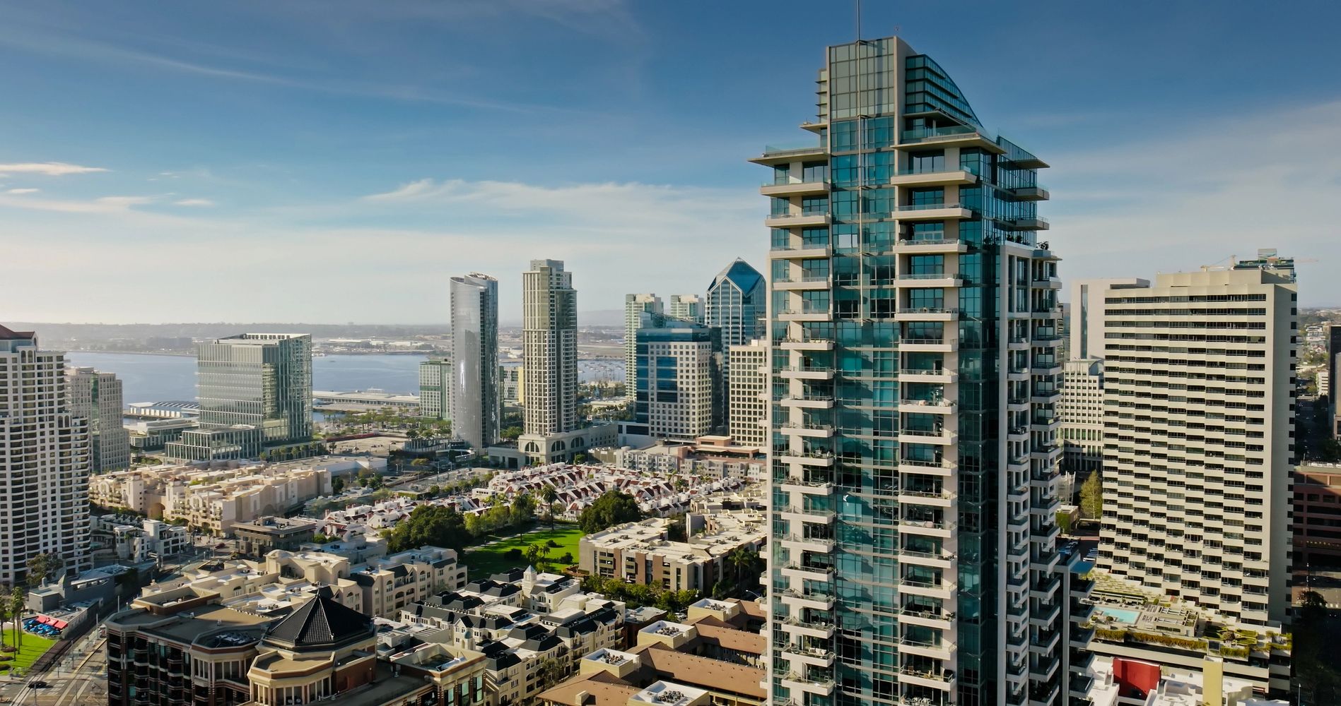 San Diego skyline with tall glass buildings and clear blue sky.