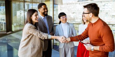 Two people shaking hands in a business setting.