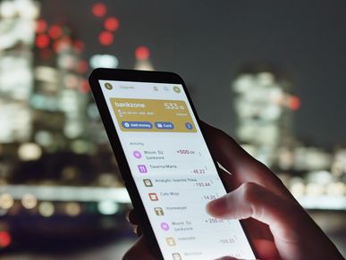 Person checking their bank balance on a smartphone at night.