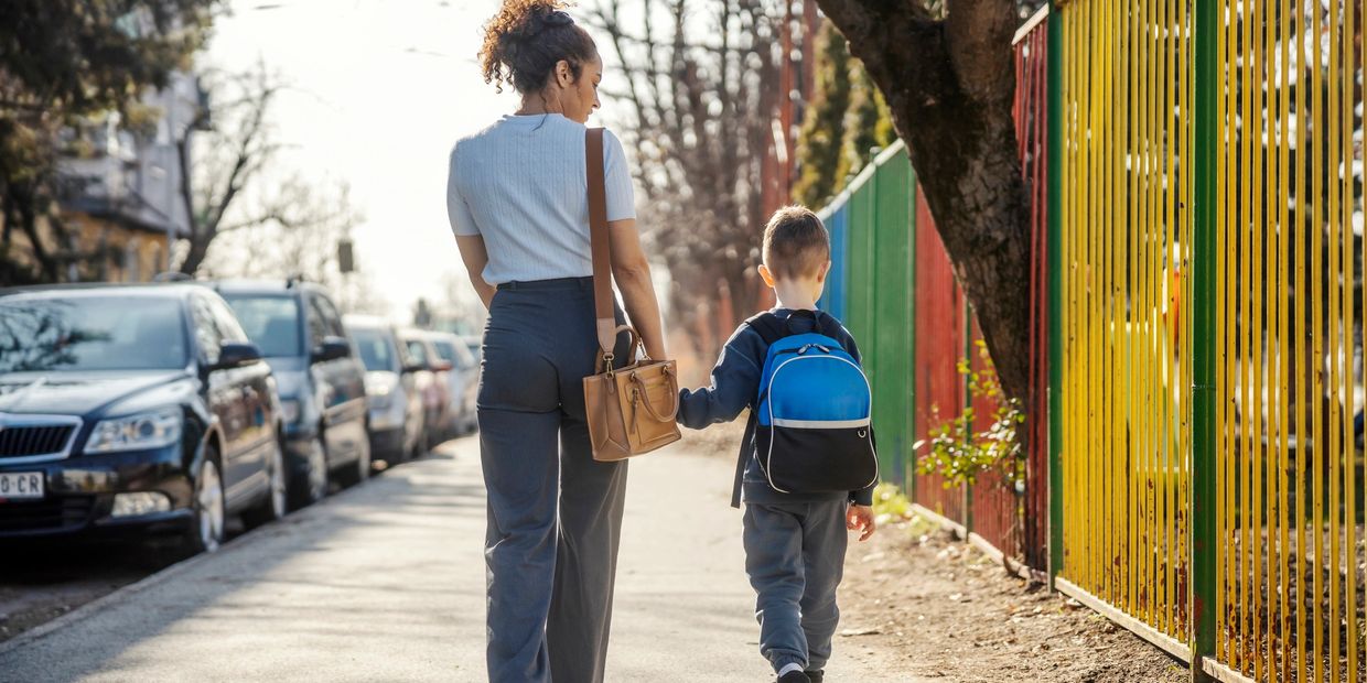 Mother and son walking to school holding hands.