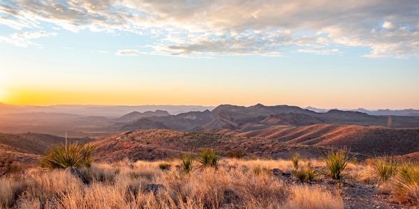 Sunset over a mountainous desert landscape.