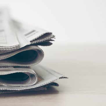 Pile de journaux pliés sur une surface.
