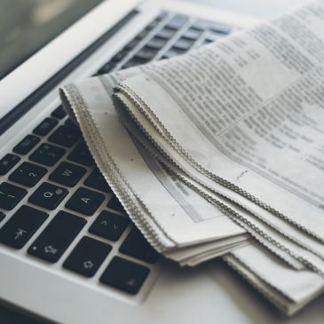 Un journal posé sur un ordinateur portable.