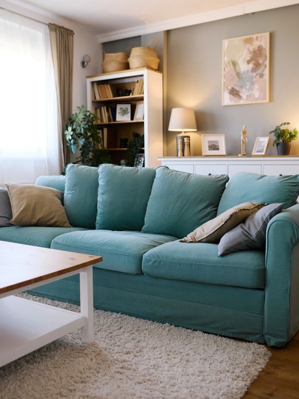 Cozy living room with teal sofa, wooden coffee table, and soft natural light.