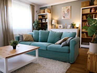 Cozy living room with teal sofa and wooden coffee table.