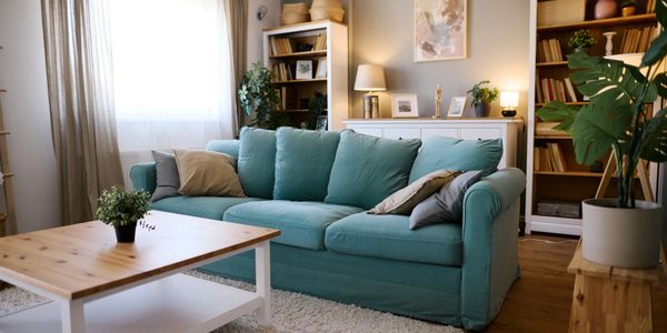 Cozy living room with teal sofa and wooden furniture.