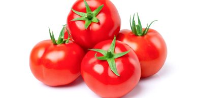 A group of four ripe red tomatoes with green stems.