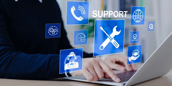 Person using laptop with digital support icons.