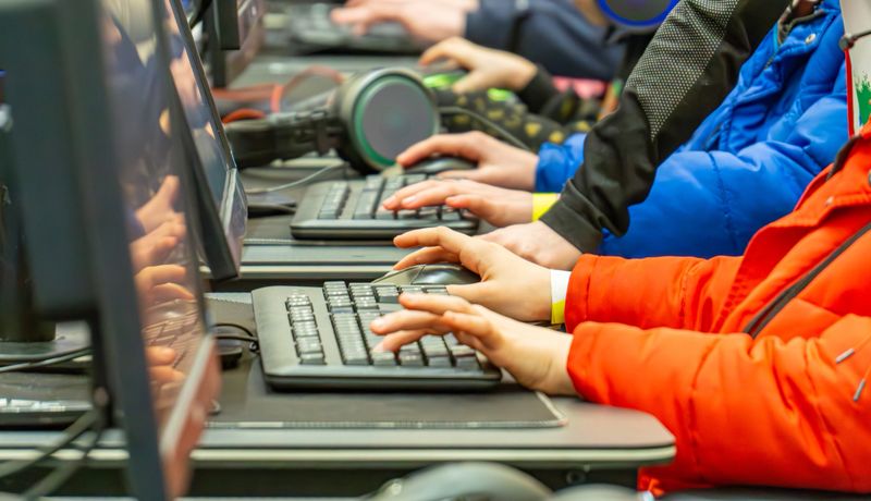 children playing computer games on laptops. computer games tournament. children's game. fair competition.