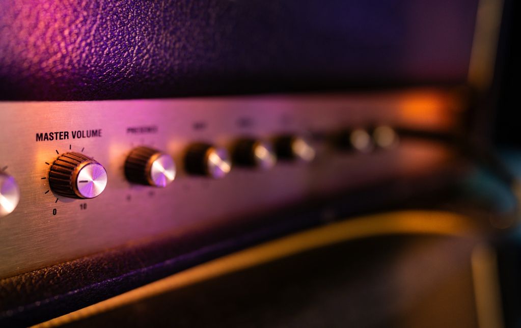 Close-up of amplifier control knobs with colorful lighting.