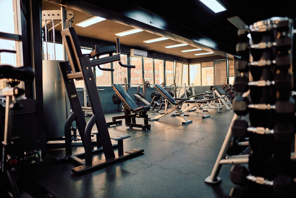 Empty gym with workout equipment and dumbbells.
