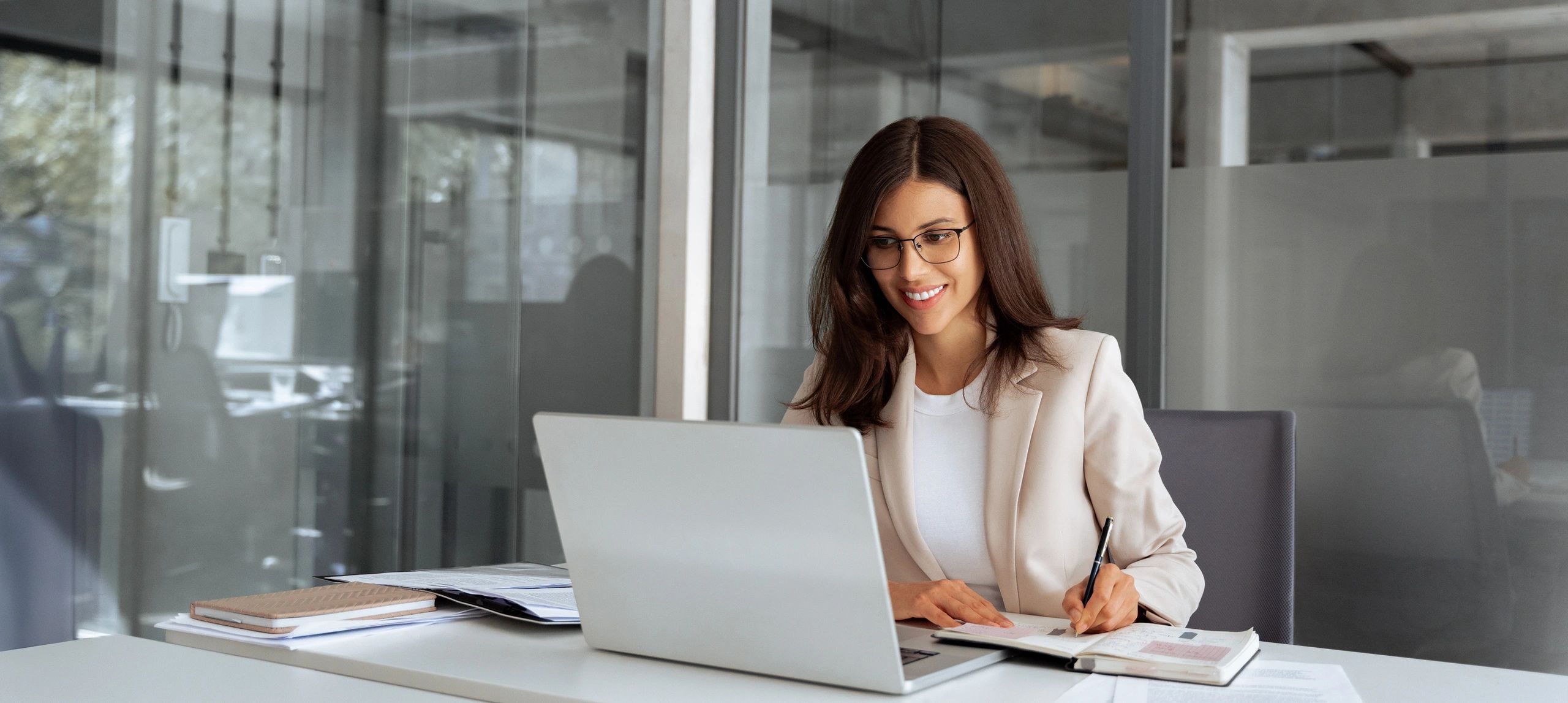 Smiling woman working at laptop in modern office.