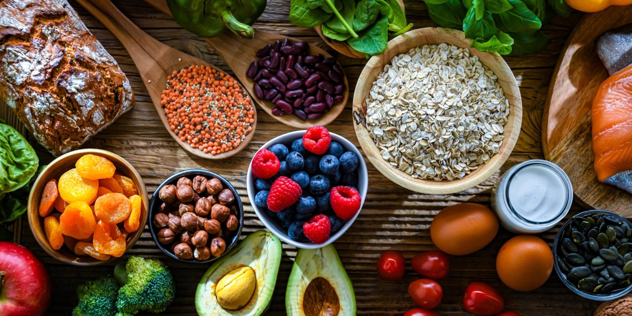 A variety of healthy foods including fruits, nuts, grains, and vegetables.