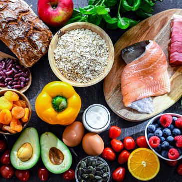 Variety of healthy foods including fruits, vegetables, fish, eggs, and grains.