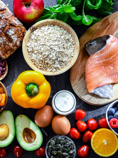 A variety of healthy foods including salmon, fruits, and vegetables.