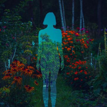 Silhouette of a person filled with a tree and water scene in a vibrant flower garden.