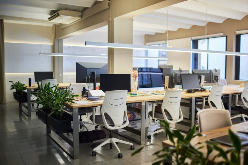 Empty open office space, desks chairs and computers.