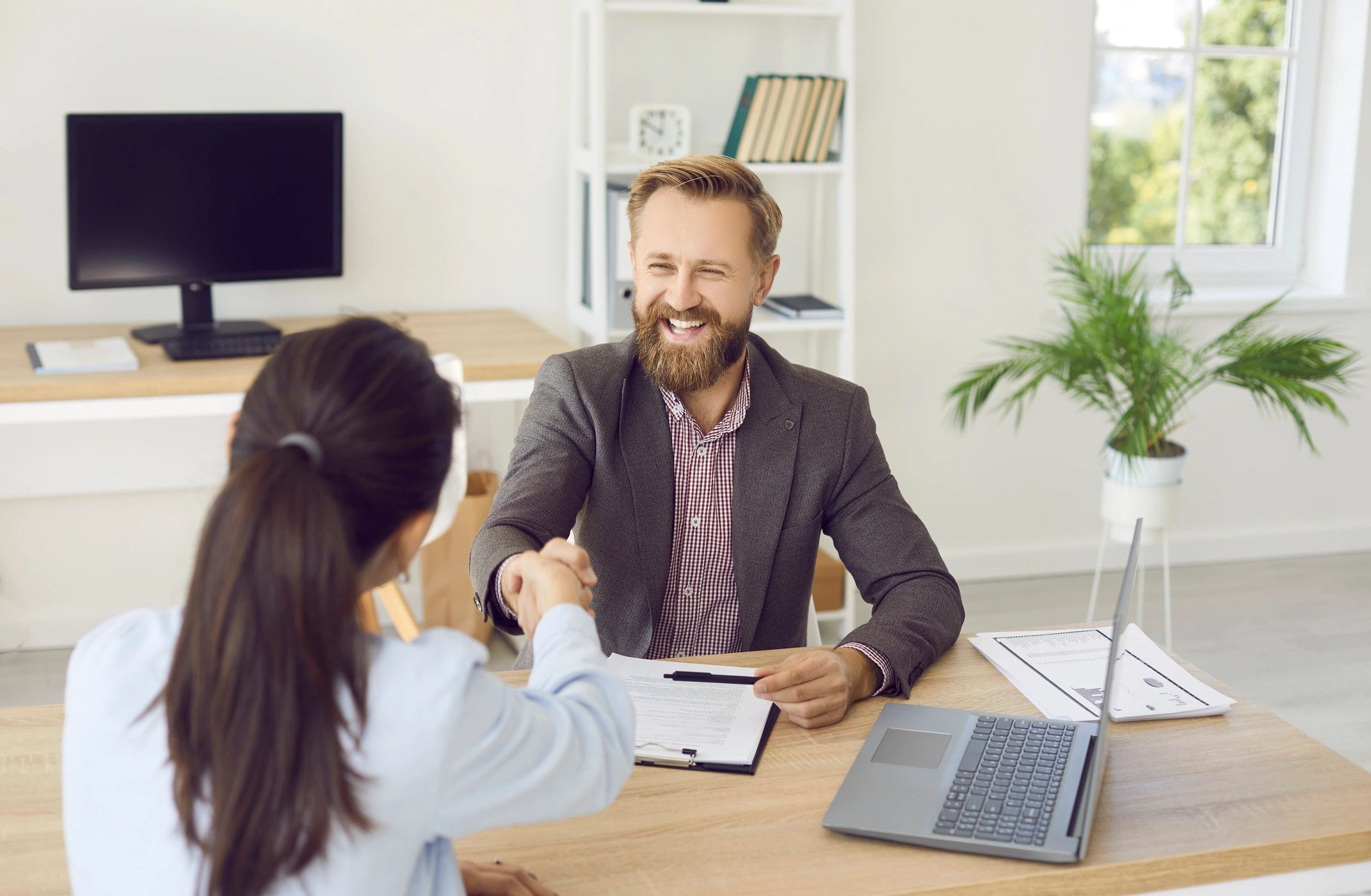 Two professionals shaking hands in an office.