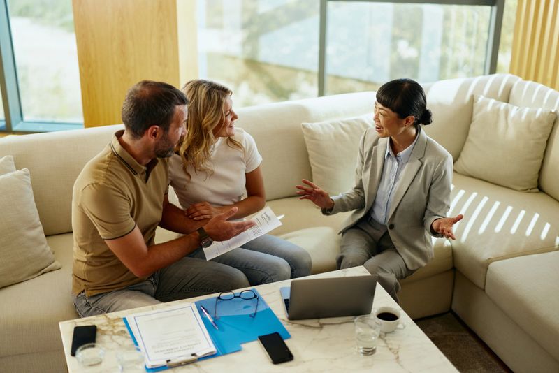 Happy mid adult couple communicating with their insurance agent during a meeting in the office.