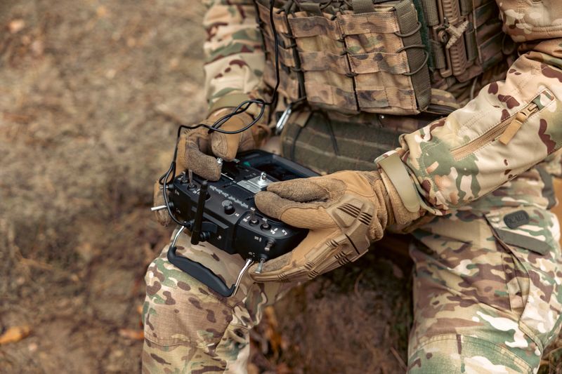 A soldier remotely controls a drone. Control panel in military hands.