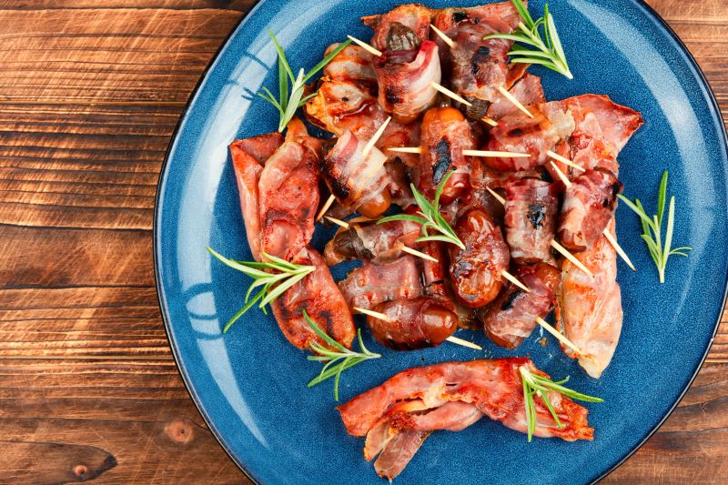 Delicious bacon-wrapped dates, delicacy appetizer. Tasty snack, healthy meal. Space for text.