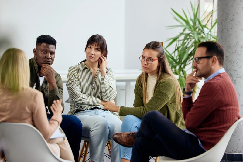 A multicultural team of individuals participates in a meaningful group discussion indoors.