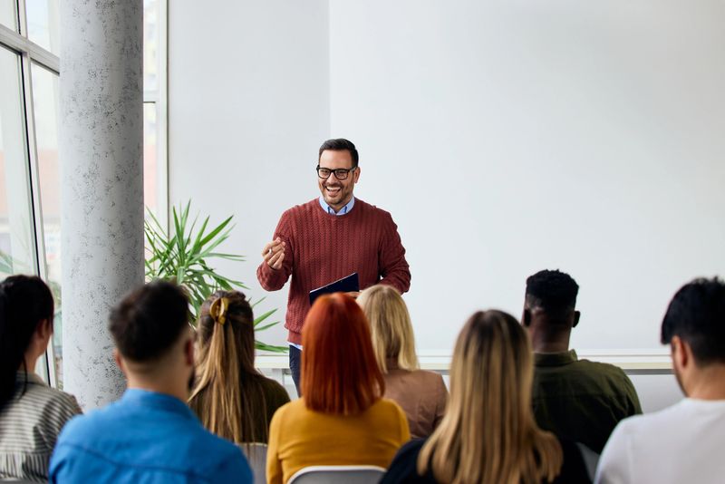 Corporate speaker delivering a motivating training session to a group of diverse employees.