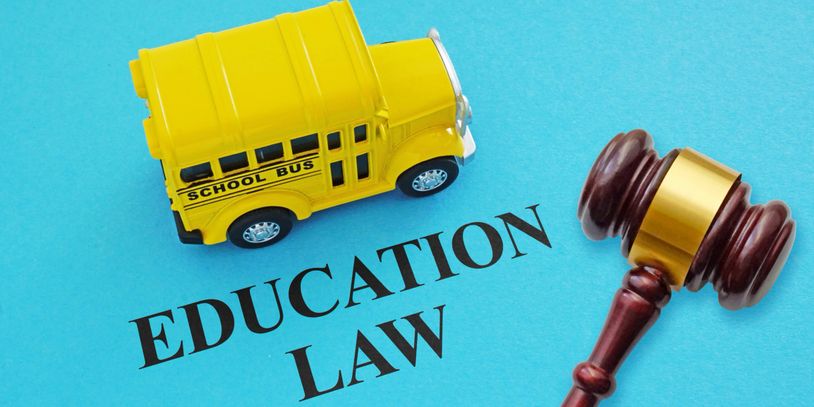 Imagen incluye un autobus escolar color amarillo, las palabras "EDUCATION LAW", y mazo del juez.