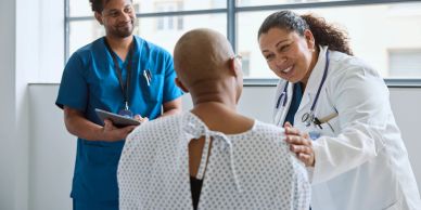 Dokter praat met patiënt terwijl verpleegkundige observeert.