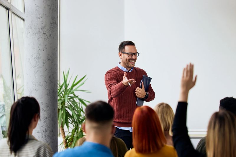 A cheerful educator interacts with a participating audience during an inclusive discussion.