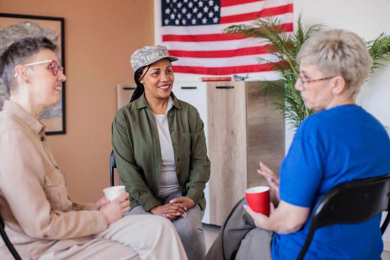 A mid adult Black female army veteran talking to her friends in a meeting room