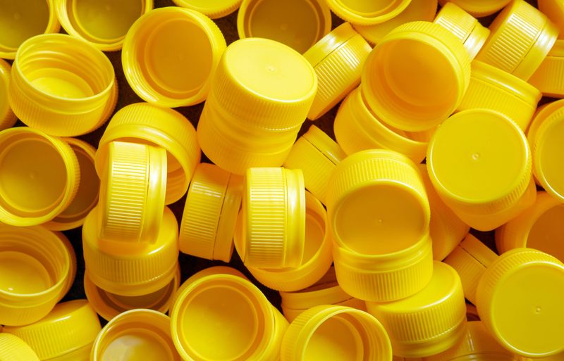yellow plastic bottle caps.Recycling collection and production processing plastic bottle caps background ,Industrial production of bottle caps made of yellow high-density polyethylene.