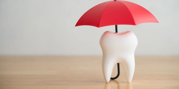 Tooth protected by a red umbrella.