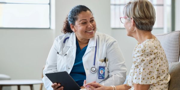 Friendly female doctor consulting a smiling elderly patient in a bright clinic.