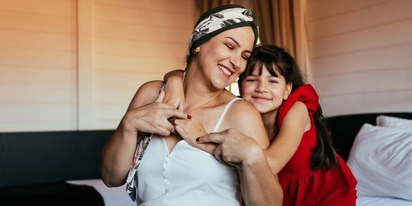 Mother and daughter hugging happily indoors.