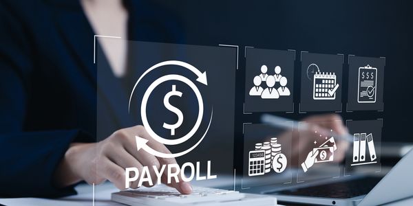 Businessperson managing payroll using a calculator and digital icons.