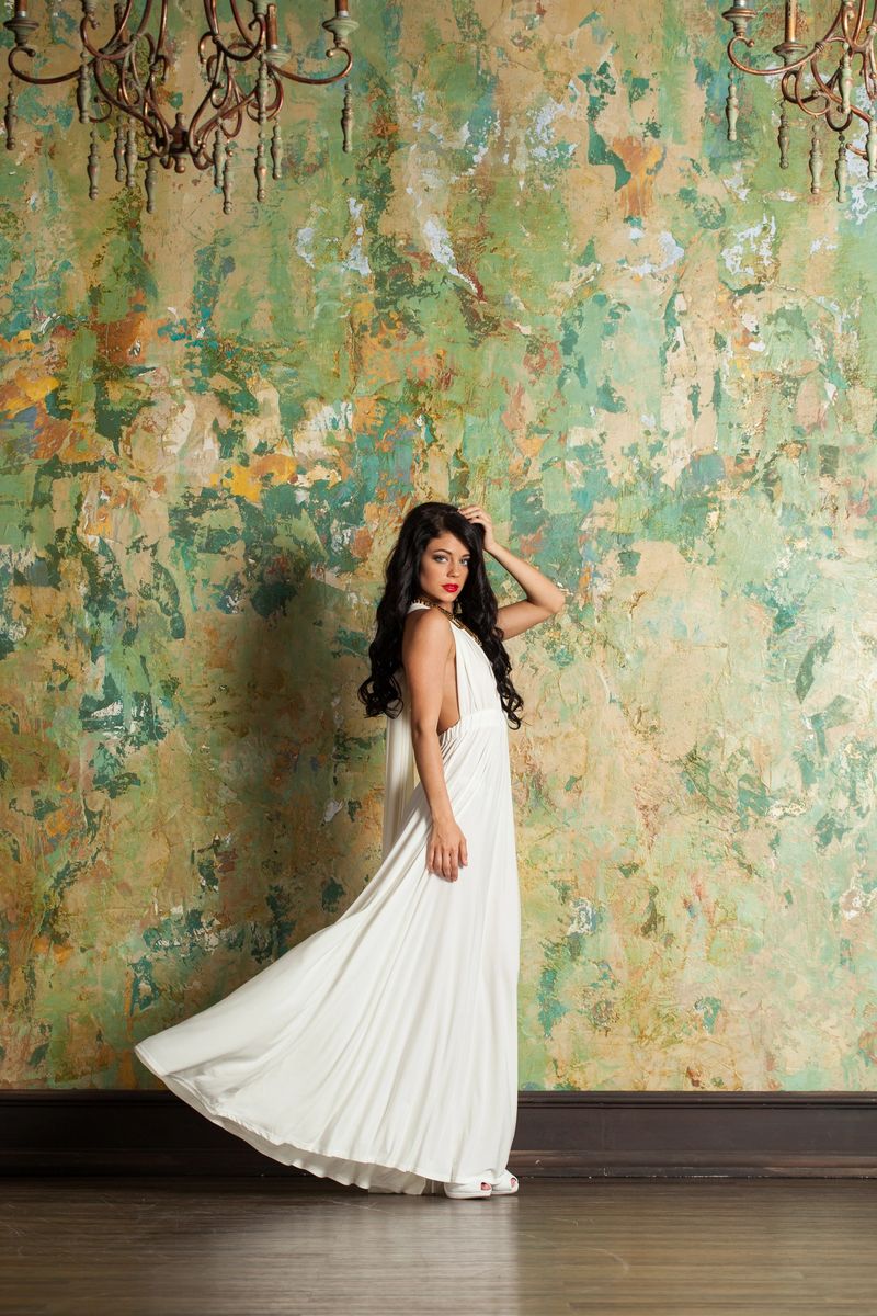 Beautiful fashion woman in white silk dress posing in perfect interior