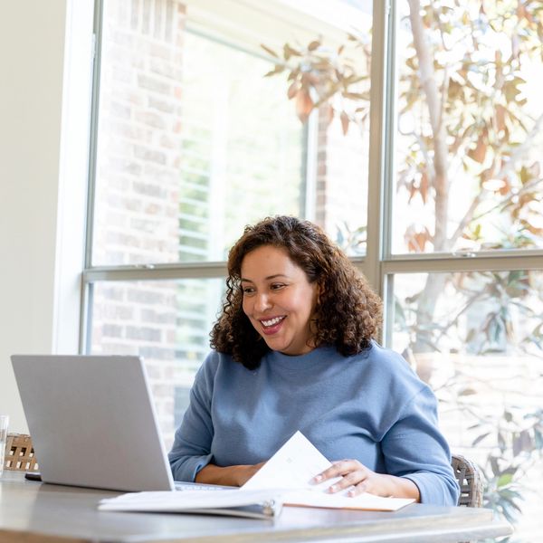 Woman happily working on laptop at home.