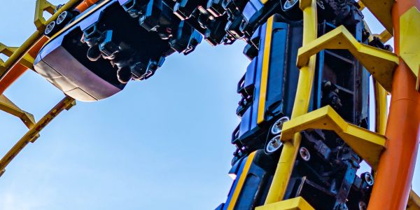 Roller coaster car looping upside down on a bright track.