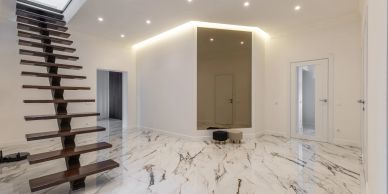 Minimalist interior with floating stairs and marble flooring.