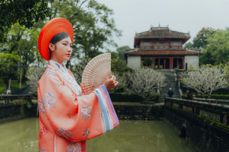 Young Vietnamese woman wearing New Year celebration dress called Nhat Binh, this is the traditional costume of Vietnamese people in the Nguyen Dynasty in Minh Mang tomb, Hue city, Vietnam