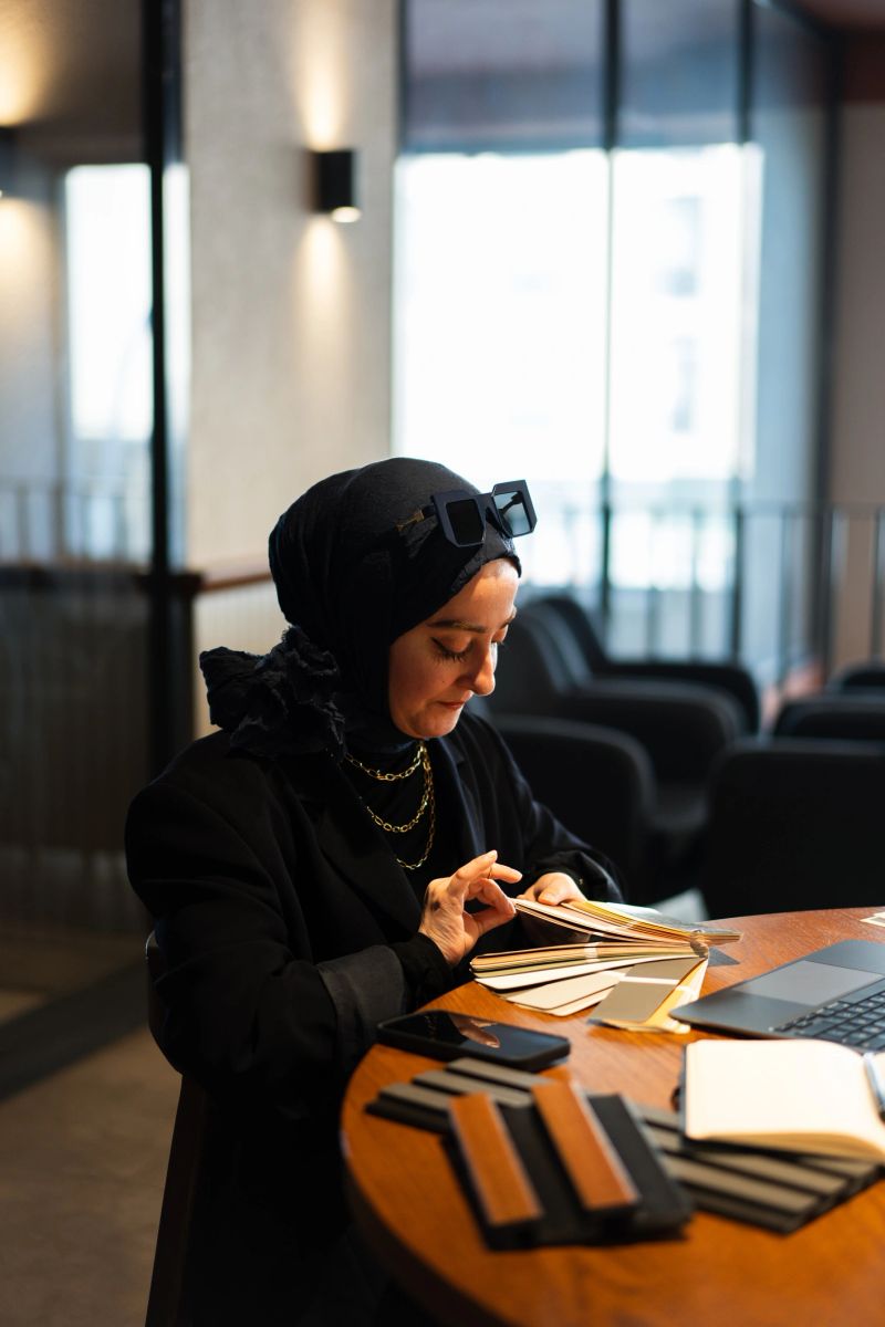 Confident muslim architect selecting materials and colors for her new project in a stylish cafe